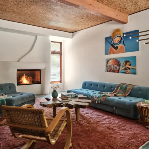 Living Room With White Walls And With Velvet Teal Sofas And With A Red Textured Rug And With A Wood Center Table