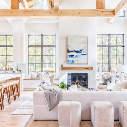 Blende Coastal Interior Design With Rustic Elegance Living Room With White Walls And Big Windows And With A Center Fireplace And With A Large Sofa